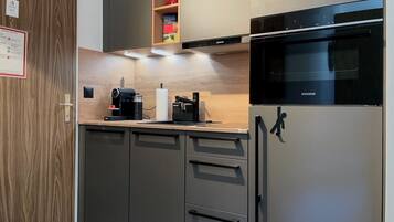Une cuisine moderne équipée d’un réfrigérateur Siemens, d’une machine à café et d’un plan de travail en bois.