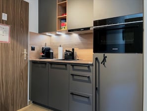 A modern kitchen with a Siemens refrigerator, a coffee machine, and a wooden countertop.