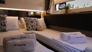 A hotel room with two beds, each with a white bedspread and pillows, and towels with 'SEASDRIVE' branding. - Sun-Kissed Sailing Adventure in Zadar, Croatia (Zadar)