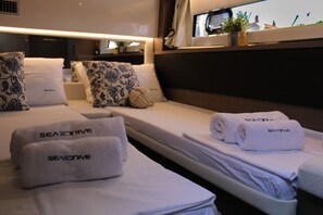 A hotel room with two beds, each with a white bedspread and pillows, and towels with 'SEASDRIVE' branding. - Sun-Kissed Sailing Adventure in Zadar, Croatia (Zadar)