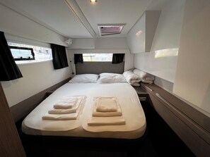 Ein gemütlicher, helles Schlafzimmer mit einem Einzelbett, einem Nachttisch und einem Fenster mit Vorhängen.