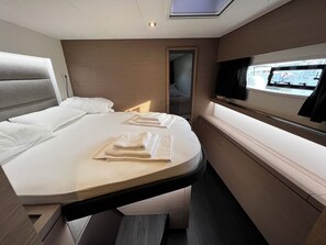Ein modernes Schlafzimmer mit einem Bett, einem Fernseher und einem Fenster.