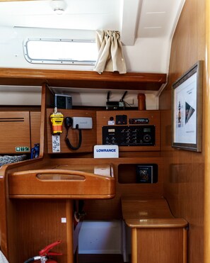 A compact, well-organized cabin with a wooden interior, a mounted television, and various control panels.