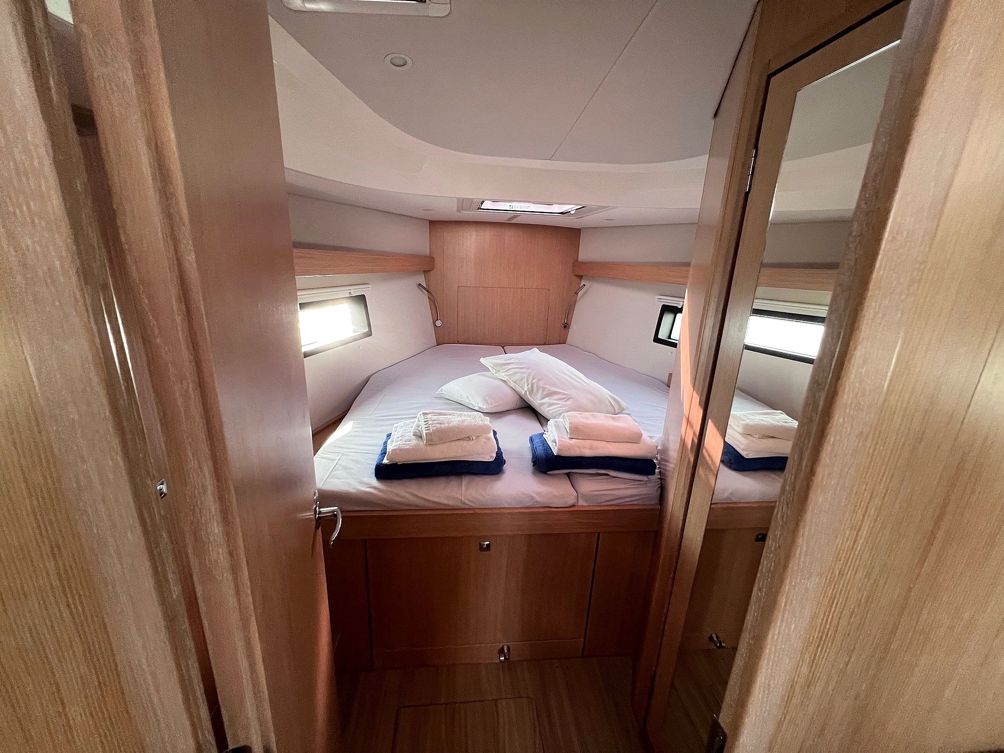 A compact, well-lit interior with a bunk bed, storage cabinets, and a small window.