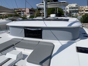 Ein Boot mit überdecter Deckfläche, einem kleinen, abgeschlossenen Bereich und einer Sitzecke.