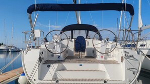 Ein Bootsdeck mit Steuerbord, einem überdachten Bereich und dem Schriftzug 'Die Sibenik' an der Seite.