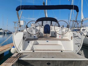 Ein Bootsdeck mit Steuerbord, einem überdachten Bereich und dem Schriftzug 'Die Sibenik' an der Seite.