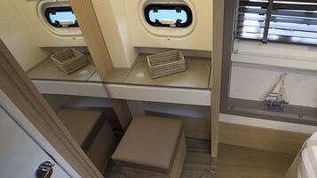 A compact RV interior with a kitchenette, two small windows, and a model sailboat decoration.