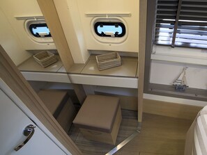 Ein kompaktes Wohnmobil-Interieur mit einer Küchenzeile, zwei kleinen Fenstern und einer Modellsegelyacht-Dekoration.