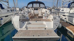 Eine Segelyacht liegt im Hafen festgemacht, mit einem Holldeck, einem Steuerrad und einer Kabine, auf der 'Fanny' steht.