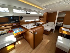 A compact galley with a sink, stove, and seating area. - Dubrovnik Delight: A Sun-Kissed Sailing Experience (Komolac)