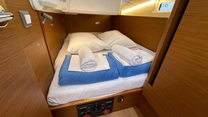 A compact, well-lit cabin with a single bed, a small control panel for lighting and power, and a window with a view. - Dubrovnik Delight: A Sun-Kissed Sailing Experience (Komolac)