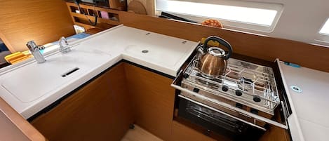 Cocina compacta con lavabo, estufa y armarios de almacenamiento.