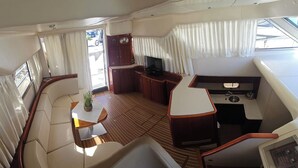 A yacht interior with a seating area, a small kitchen, and a TV. - Sun-Kissed Sailing Adventure in Sibenik, Croatia (Primošten)