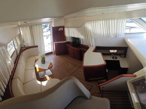 A yacht interior with a seating area, a small kitchen, and a TV. - Sun-Kissed Sailing Adventure in Sibenik, Croatia (Primošten)