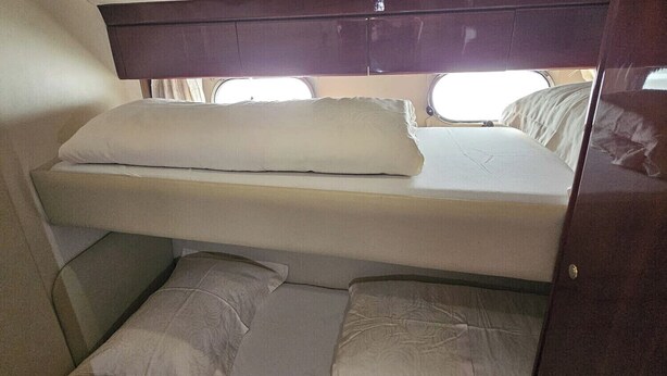 A bunk bed with a window above it, a green bedspread, and a wooden headboard. - Sun-Kissed Sailing Adventure in Sibenik, Croatia (Primošten)