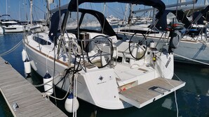 A sailboat docked at a marina with a covered cockpit, winches, and a starboard steering wheel. - Sun-Kissed Sailing Adventure in Zadar, Croatia (Drage)