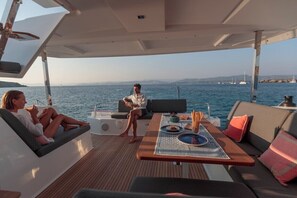 A yacht with a dining area, seating, and a view of the sea. - Sun-Kissed Sailing Adventure in the Ionian Islands, Lefkada (Lefkada)