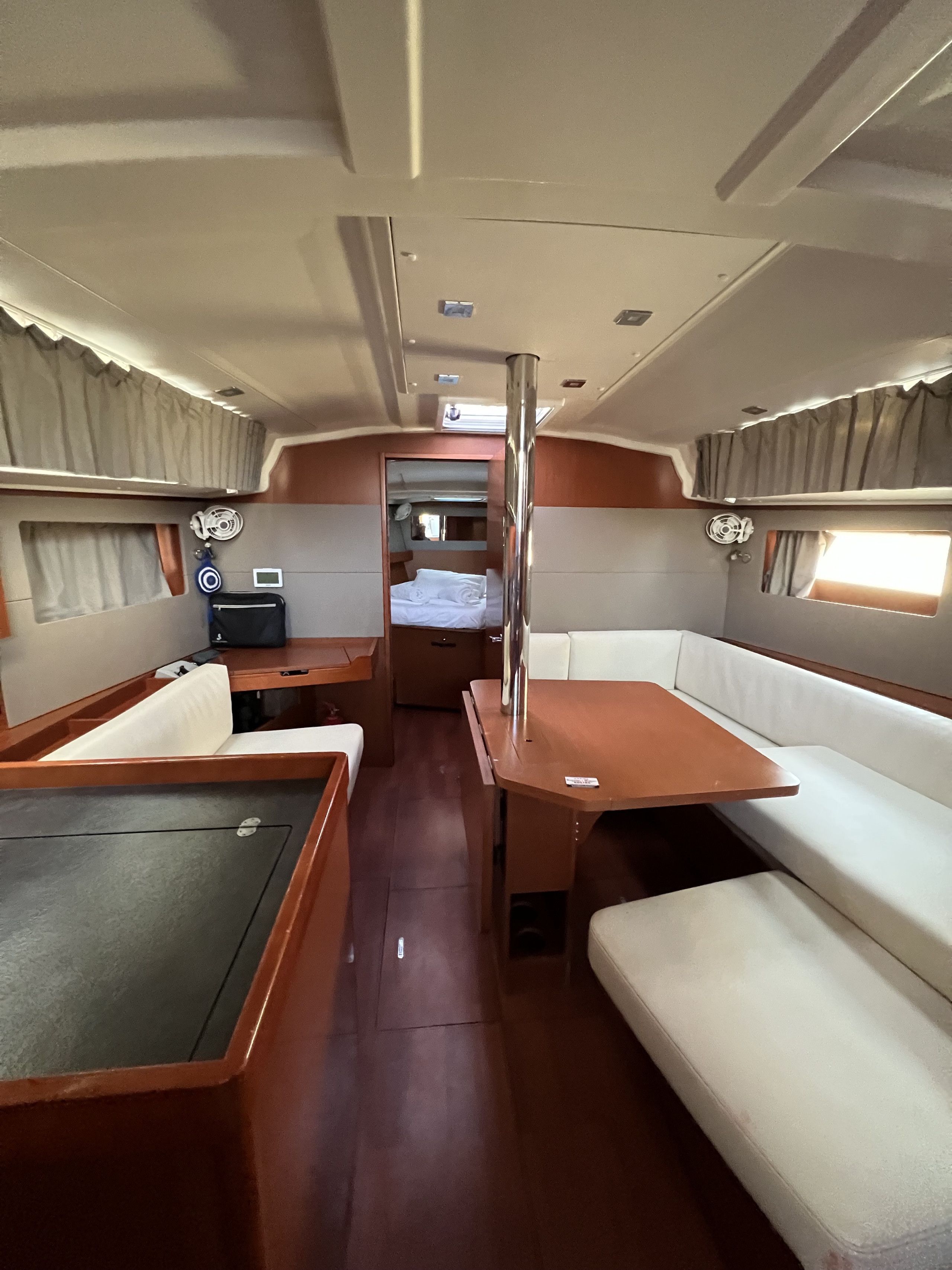 Un intérieur compact avec une table centrale, des sièges de chaque côté et une petite fenêtre.