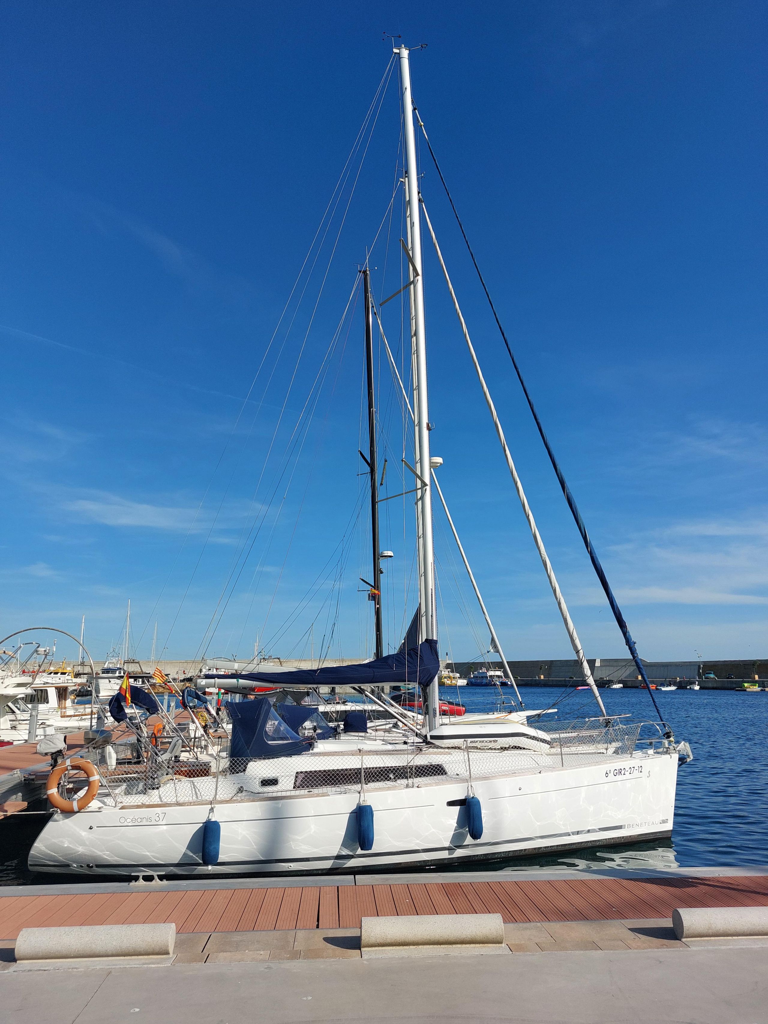 A sailboat docked at a marina with a clear sky.