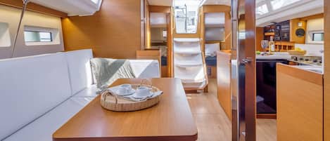 Un intérieur compact et bien éclairé, comprenant un coin repas, une kitchenette et un espace salon.