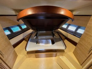 A room with a curved ceiling, a central bed, and a window with blinds.