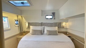 Ein Bett mit Kopfteil, einem kleinen Fenster und einem Oberlicht.