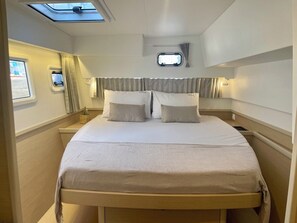 Ein Bett mit Kopfteil, einem kleinen Fenster und einem Oberlicht.