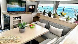 Ein gemütlicher, kleiner Wohnbereich mit Fernseher, Sitzgelegenheit und Topfpflanzen.