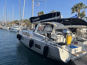 A marina with multiple sailboats docked, featuring a prominent 'ARCHON' sailboat with a covered deck and a visible 'HONDA' engine. - Sun-Kissed Sailing Adventure in the Dodecanese Islands (Rodos)
