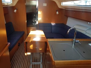 A compact galley with a sink, a small table, and seating areas.
