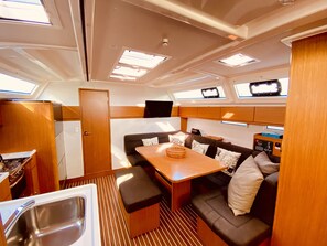 A compact galley with a sink, a stove, and a small dining table. - Sun-Kissed Sailing Adventure in the Ionian Islands, Lefkada (Lefkada)