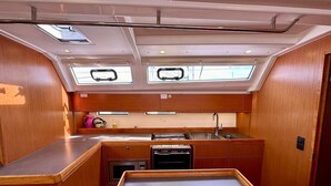 A compact kitchen with a central island, a sink, and a stove. There are skylights above the windows. - Sun-Kissed Sailing Adventure in Zadar, Croatia (Bibinje)
