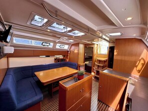 A compact interior with a sofa, a small table, and a kitchenette area. - Sun-Kissed Sailing Adventure in Zadar, Croatia (Bibinje)