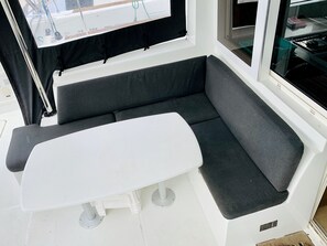 A boat interior with a white table and a cushioned seating area. - Sun-Kissed Sailing Adventure in Isla de Mahe, Seychelles (Providence)