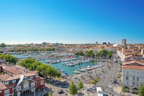 A marina with boats, a cityscape with historic buildings, and a clear sky.