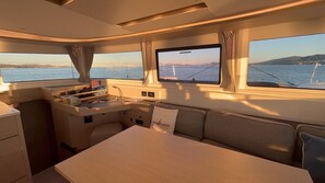 Eine kleine Kombüze mit Spüle, Stauraum und einem Fenster mit Meerblick.