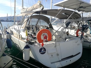 A sailboat docked at a marina with life rings and a logo indicating 'Perfect Sailing.' - Sun-Kissed Sailing Adventure in Islas Esporadas (Skiathos)