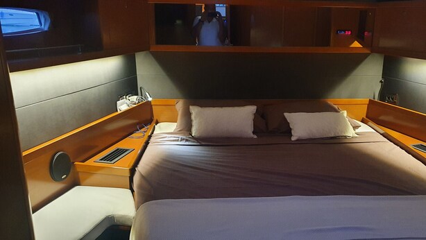A bed with two pillows, a headboard, and wooden side tables with a small mirror. - Sun-Kissed Sailing Adventure in the Ionian Islands, Lefkada (Lefkada)
