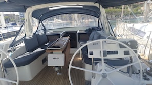 A boat's interior with a steering wheel, seating, and a B&G control panel.