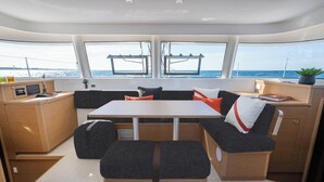 A modern interior with a central table, seating, and a view of the sea. - Sun-Kissed Sailing Adventure in Zadar, Croatia (Zadar)