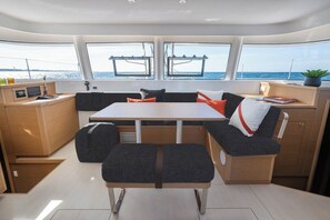 A modern interior with a central table, seating, and a view of the sea. - Sun-Kissed Sailing Adventure in Zadar, Croatia (Zadar)