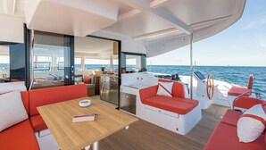 A yacht interior with a dining area, a kitchen, and a seating area with a view of the sea. - Sun-Kissed Sailing Adventure in Zadar, Croatia (Zadar)