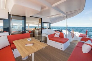 A yacht interior with a dining area, a kitchen, and a seating area with a view of the sea. - Sun-Kissed Sailing Adventure in Zadar, Croatia (Zadar)