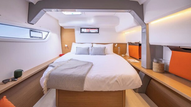 A modern, compact bedroom with a bed, bedside tables, a mounted TV, and a window. - Sun-Kissed Sailing Adventure in Zadar, Croatia (Zadar)