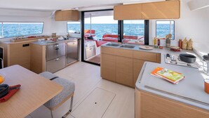A compact galley with a sink, stove, and dining area on a yacht. - Sun-Kissed Sailing Adventure in Zadar, Croatia (Zadar)