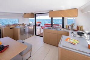 A compact galley with a sink, stove, and dining area on a yacht. - Sun-Kissed Sailing Adventure in Zadar, Croatia (Zadar)