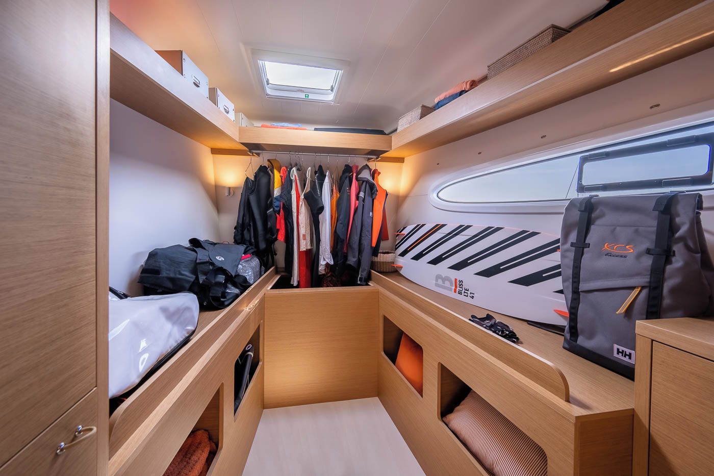 A compact, well-lit interior with a bunk bed, storage cabinets, and a seating area.