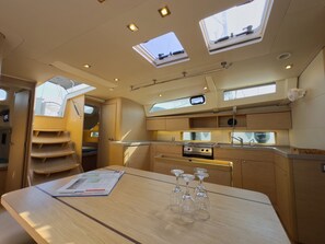 A compact kitchen with a central island, overhead skylights, and a small window. - Sun-Kissed Sailing Adventure in Islas Sarónicas (Alimos)