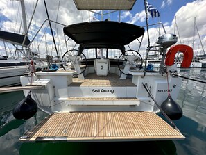 Ein Bootsdeck mit einem 'Sail Away'-Schild, einem Steuerrad und der Kennnummer 'NO 12187'.